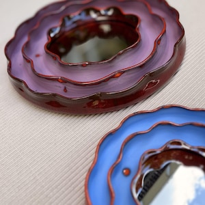 Handmade flower-shaped wall mirrors in purple and blue glazed ceramic frames, decorative scalloped mirror set, unique artistic home decor.