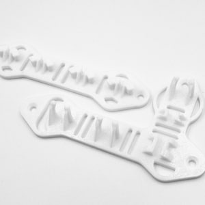Pode incluir: Duas pe&ccedil;as de pl&aacute;stico branco impressas em 3D com v&aacute;rios orif&iacute;cios e sali&ecirc;ncias. As pe&ccedil;as s&atilde;o projetadas para serem usadas juntas para criar um objeto funcional.