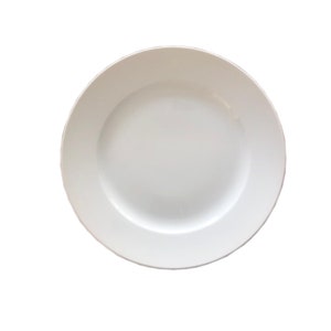 May include: A white ceramic dinner plate with a slightly raised rim.