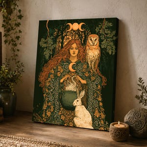May include: A rectangular canvas print featuring a central figure with long hair wearing a cloak adorned with leaves, holding a steaming cauldron. A white rabbit sits beside the figure, and an owl perches on the shoulder. A triple moon symbol is above.
