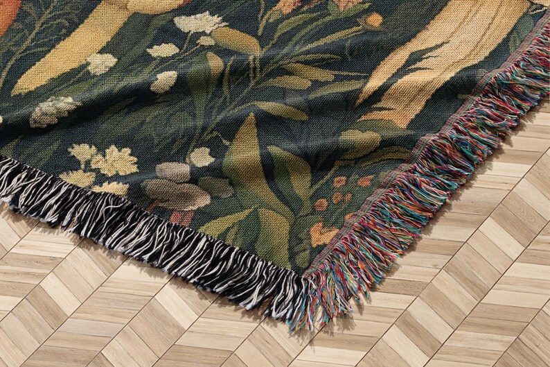 May include: A woven tapestry throw blanket with a floral pattern in shades of green, brown, and yellow. The blanket has a fringe border with black and multi-colored threads.