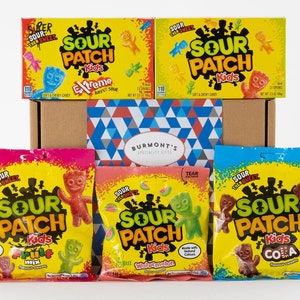 May include: A gift box filled with five bags of Sour Patch Kids sweets. The bags are yellow with red, pink, and blue accents. The bags feature the Sour Patch Kids logo and different flavours, including Extreme Sour, Fruit Mix, Watermelon, and Cola.