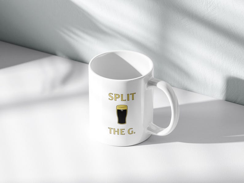 May include: White ceramic mug with a black and gold graphic of a pint glass and the text "SPLIT THE G."