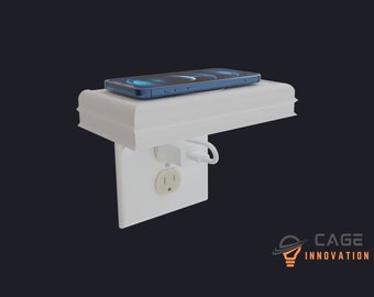 May include: A white wall-mounted shelf with a built-in wireless charging pad for a smartphone. The shelf is attached to a standard electrical outlet. The phone is charging on the pad.