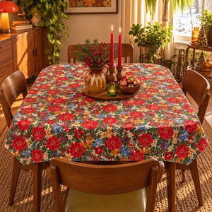 May include: A rectangular tablecloth featuring a dense, colourful pattern of red poinsettias, green holly leaves, and small blue and gold accents. The fabric covers a wooden dining table surrounded by four wooden chairs with green upholstered seats.