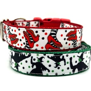 May include: Two dog collars with a white background and black polka dots. One collar features a red and black pattern of ruby slippers and the other features a green and black pattern of witches.