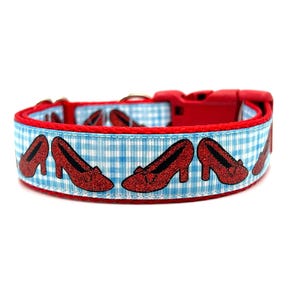 May include: Red dog collar with a blue and white gingham pattern and ruby slippers printed on it.