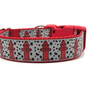 Puede incluir: Collar de perro rojo con un patrón plateado y negro de bocas de incendios.