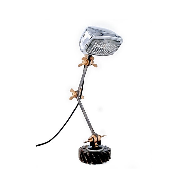 Lampe de table recyclée à partir d'une ancien phare  et d'un pignon avec bras pivotant composé de clés et de boulons ailés.