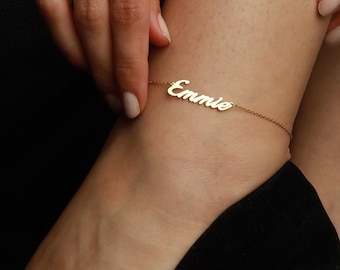 Puede incluir: Un brazalete de tobillo de oro con el nombre "Emme" escrito en cursiva.