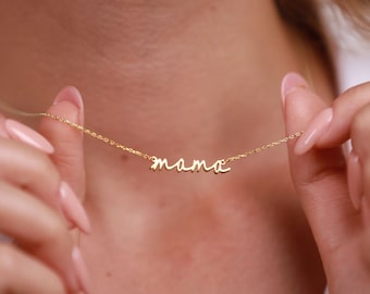 May include: A gold necklace with a cursive 'mama' pendant.