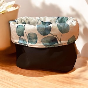 May include: A black fabric storage basket with a removable beige fabric liner featuring a green watercolor leaf pattern.