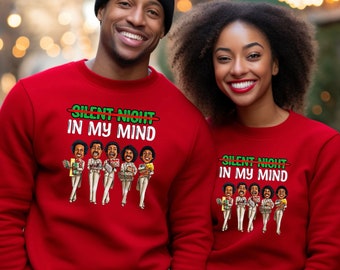 May include: Red sweatshirts with the text "SILENT NIGHT IN MY MIND" and a cartoon illustration of a group of people in white suits holding gifts. The image features two people wearing the sweatshirts.