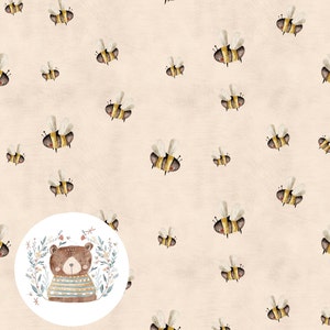 Könnte beinhalten: Ein beigefarbener Hintergrund mit einem sich wiederholenden Muster aus gelben und schwarzen Bienen. Ein Kreis in der Mitte des Bildes zeigt einen braunen Bären, der einen blau-braunen gestreiften Pullover trägt, umgeben von grünen Blättern und Blumen.