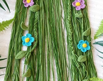 May include: Green crocheted hat with a fringe and colorful crocheted flowers. The hat has a green crocheted braid on the back.