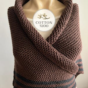 May include: A brown knitted shawl with black stripes. The shawl is made of 100% cotton.