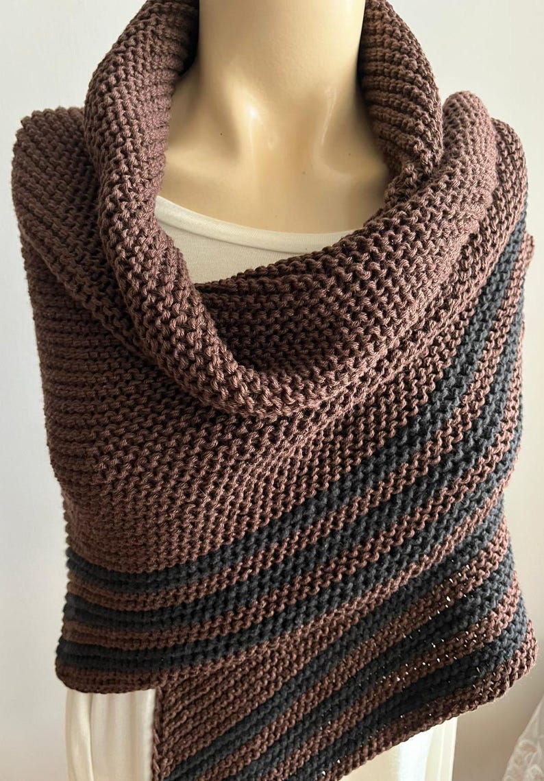 May include: A brown and black striped knitted shawl with a cowl neck.
