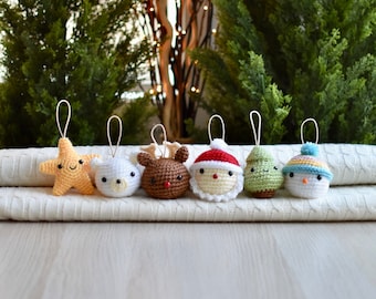 May include: Six crocheted Christmas ornaments with different designs, including a star, a bear, a reindeer, Santa Claus, a Christmas tree, and a snowman. The ornaments are all white with different colored accents.
