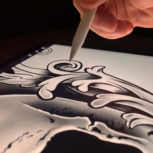 Pu&ograve; includere: Primo piano di un disegno digitale di uno scheletro con un'ornamento floreale in cima, disegnato su un tablet con uno stilo.
