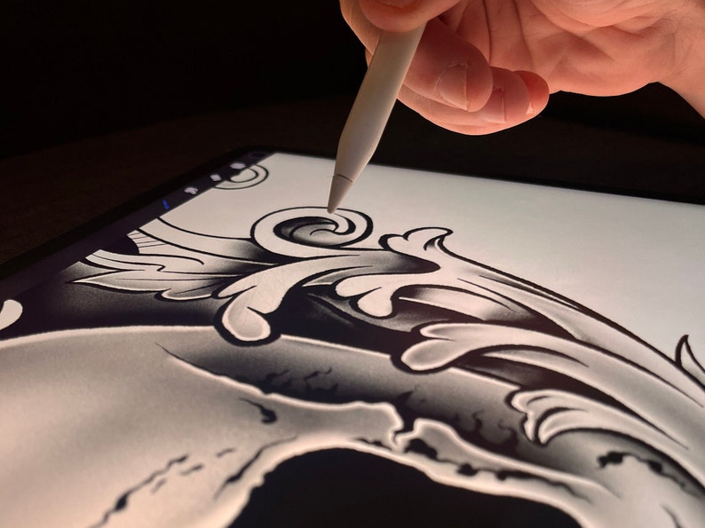 Pu&ograve; includere: Primo piano di un disegno digitale di uno scheletro con un'ornamento floreale in cima, disegnato su un tablet con uno stilo.