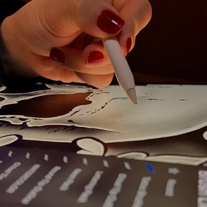 Pu&ograve; includere: Una mano con smalto rosso usa uno stilo bianco per disegnare un teschio bianco e nero su un tablet da disegno digitale.