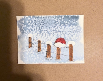 Può includere: Un acquerello raffigura una scena invernale con cinque pali di recinzione in legno marrone collegati da un filo sottile. I pali sono coperti di neve bianca e uno di essi presenta un cappello rosso brillante. Lo sfondo è un lavaggio blu e bianco.