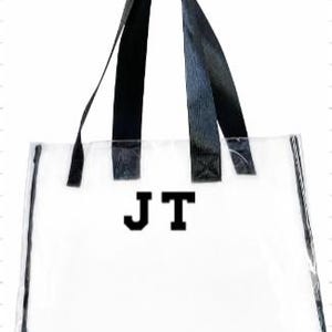 Może przedstawiać: Przezroczysta torba typu tote z czarnymi uchwytami i wykończeniami. Torba posiada inicjały "JT" w pogrubionej, czarnej czcionce. Tekst "FONT 1" jest wydrukowany u g&oacute;ry. Torba jest przeznaczona do przenoszenia przedmiot&oacute;w.