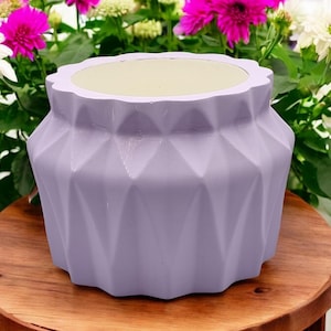 Puede incluir: Un macetero geométrico lavanda con un patrón de diamante. El macetero está hecho de cerámica y tiene un acabado liso y brillante.
