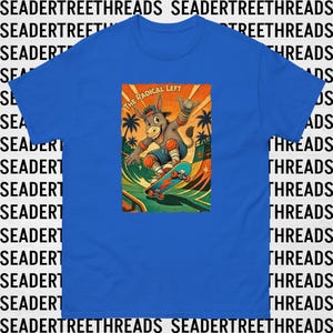 Può includere: Una t-shirt blu brillante a maniche corte con la grafica di un asino dei cartoni animati che fa skateboard su una rampa. L'asino indossa un berretto, ginocchiere e polsiere. Il testo THE RADICAL LEFT è scritto in lettere arancioni.