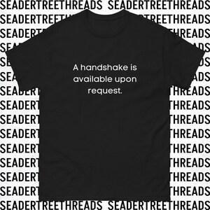 May include: Black t-shirt with white text that reads "A handshake is available upon request."