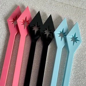 May include: Six plastic hair clips in three colors: pink, black, and light blue. Each clip is shaped like a diamond with a star cut out in the center.