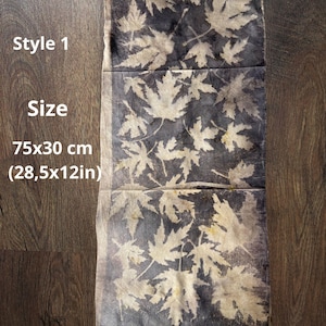 Puede incluir: Textil rectangular con fondo gris oscuro y un patrón de hojas de arce beige claro. El texto "Style 1" y "Size" son visibles, junto con las dimensiones 75x30 cm. El textil se muestra sobre una superficie de madera oscura.