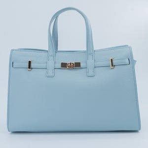 Italian Handmade Leather Bag crafted in Florence from genuine Italian leather, this elegant light blue top handle bag & tote bag blends timeless design with everyday functionality. Featuring structured lines, a refined gold-tone turn-lock closure, and double top handles, it offers a spacious interior with secure zip closure. A versatile leather tote bag made in Italy, perfect for work, city wear, or as a thoughtful gift for her.