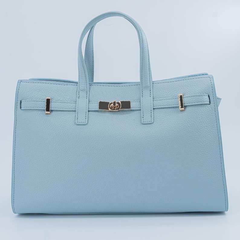 Italian Handmade Leather Bag crafted in Florence from genuine Italian leather, this elegant light blue top handle bag & tote bag blends timeless design with everyday functionality. Featuring structured lines, a refined gold-tone turn-lock closure, and double top handles, it offers a spacious interior with secure zip closure. A versatile leather tote bag made in Italy, perfect for work, city wear, or as a thoughtful gift for her.
