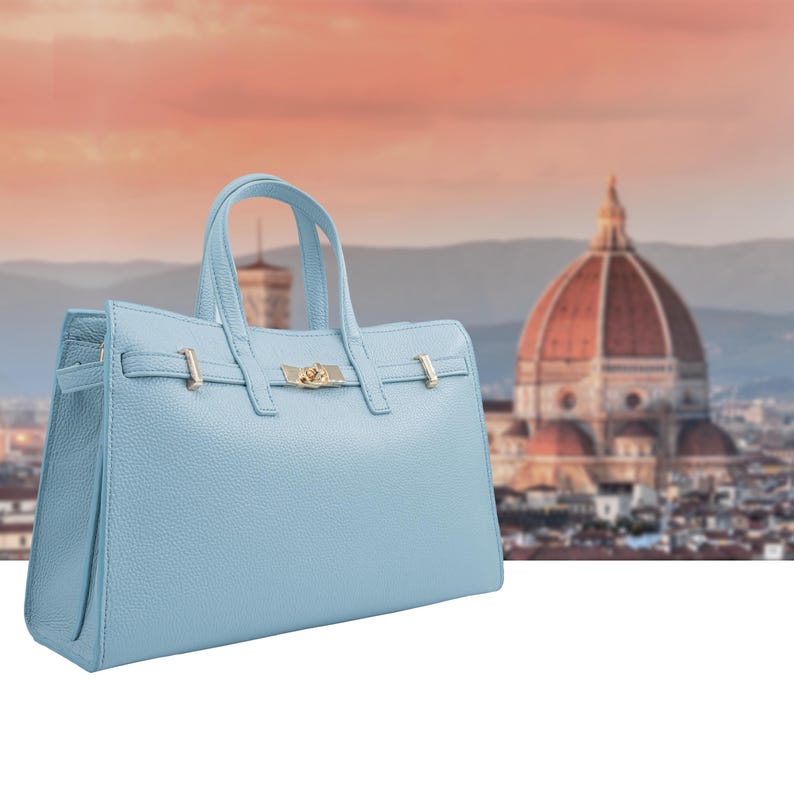 Italian Handmade Leather Bag crafted in Florence from genuine Italian leather, this elegant light blue top handle bag & tote bag blends timeless design with everyday functionality. Featuring structured lines, a refined gold-tone turn-lock closure, and double top handles, it offers a spacious interior with secure zip closure. A versatile leather tote bag made in Italy, perfect for work, city wear, or as a thoughtful gift for her.