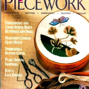 May include: A magazine cover for Piecework, a publication for needlework and history. The cover features a cross-stitch design of a butterfly and snail in a green and brown garden setting. The magazine title is in large, bold letters and the cover also includes the words "Cross Stitch", "Knitting", "Embroidery", "Quilting", and "Crochet".