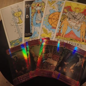 Könnte beinhalten: Eine Sammlung von Tarotkarten mit verschiedenen Illustrationen und Texten. Die Karten zeigen Figuren, Symbole und Szenen, darunter "The Lovers" und "The High Priestess". Die Karten haben ein mystisches Thema mit leuchtenden Farben und detaillierten Kunstwerken.
