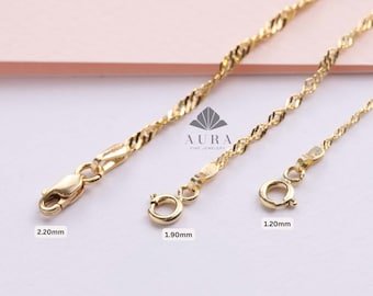 May include: Three gold chains with different widths, 2.20mm, 1.90mm, and 1.20mm. The chains are made of a delicate, twisted design. The chains are on a pink background with the text "AURA FINE JEWELLERY".