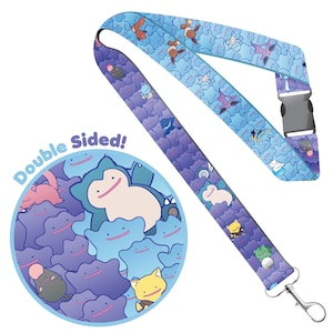 May include: Double-sided lanyard with a blue background and a repeating pattern of purple and blue Pokemon characters. The text "Double Sided!" is printed on the lanyard.