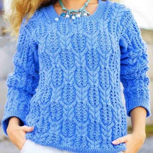 May include: A blue knitted sweater with a textured pattern. The sweater has long sleeves and a round neckline. The intricate design features a series of vertical and diagonal patterns. The color is a vibrant, medium blue.