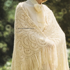 May include: Cream-colored crocheted shawl with a circular pattern and fringe. The shawl is draped over a white blouse and pants. The image includes the text "https://sonyacrossstitch.etsy.com".