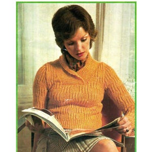 May include: A woman wearing a mustard yellow knitted sweater with a shawl collar, reading a magazine. The sweater has a textured pattern. She is wearing a patterned scarf and a plaid skirt. The background is a light color.