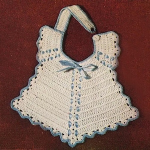 May include: A handmade, white crochet baby bib with a scalloped edge and blue trim. The bib features a blue ribbon bow and a strap to go around the neck. The bib is designed with a vintage aesthetic.