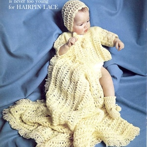 May include: A baby in a yellow crocheted outfit, including a bonnet, sweater, blanket, and booties, sits on a blue surface. The text "A BABY is never too young for HAIRPIN LACE" is visible in the upper left corner.