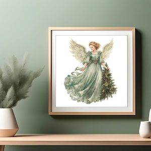 Puede incluir: Una ilustración enmarcada de un ángel con alas, que lleva un vestido verde fluido y sostiene un pequeño árbol de Navidad con adornos dorados. El ángel tiene el pelo largo y rubio y una expresión suave.