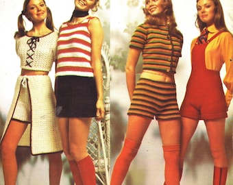 May include: Vintage magazine cover featuring women in knitted outfits. The outfits include a white crochet set, a red and white striped top with a black skirt, a striped top and shorts set, and red overalls. The text "HOT PANTS" is displayed in large orange letters.