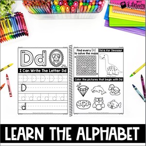 May include: A spiral-bound workbook with the text "I Can Write The Letter Dd" and "Dd is for Dinosaur". The pages include tracing exercises, a maze, and pictures to color. Crayons and markers surround the workbook.
