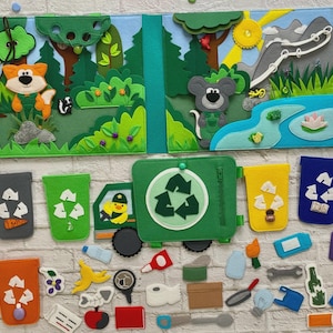 May include: A felt quiet book featuring a forest scene with a fox and mouse, alongside a green recycling truck toy. Below are five coloured recycling bins with white symbols and various small felt waste items like bottles, food, and tools.
