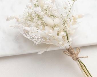 May include: A bouquet of dried white flowers tied with twine. The bouquet includes white baby's breath, white pampas grass, and other white dried flowers.