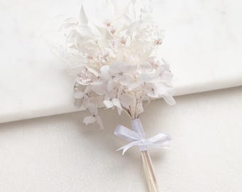 May include: A small bouquet of dried white and pink flowers tied with a white ribbon.